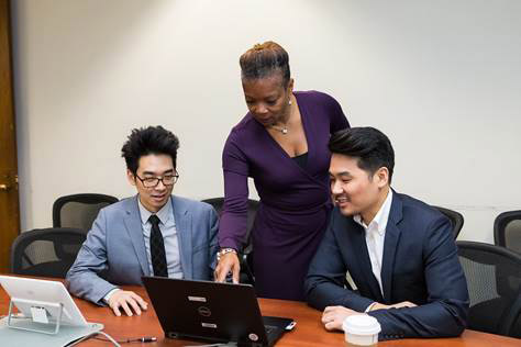 A group of people sitting at a desk  Description automatically generated