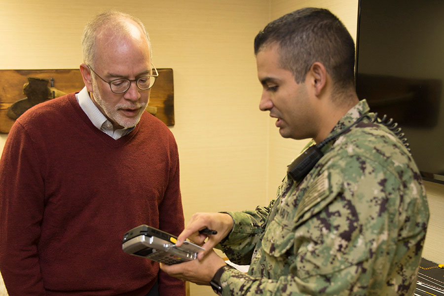 Chief Counsel and sailor looking at device